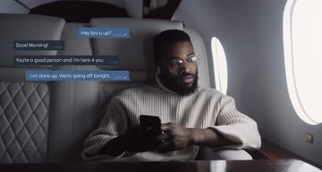 Man texting in an airplane with text bubbles on top of him.