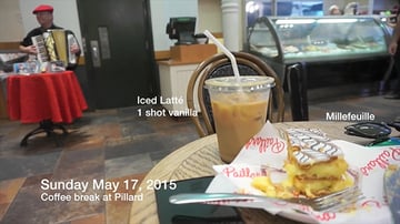 A milefeuile and iced latte sitting on a coffee shop table
