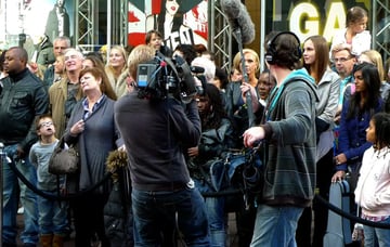 two person film crew and crowd