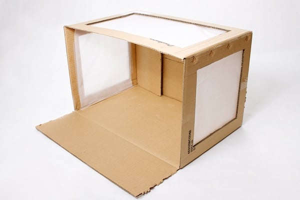 Cardboard box with paper attached over the windows