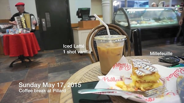 A milefeuile and iced latte sitting on a coffee shop table