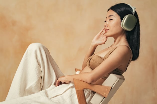 model listening in headphones on chair