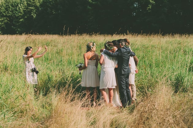 A wedding photographer photographing a group shot at a wedding