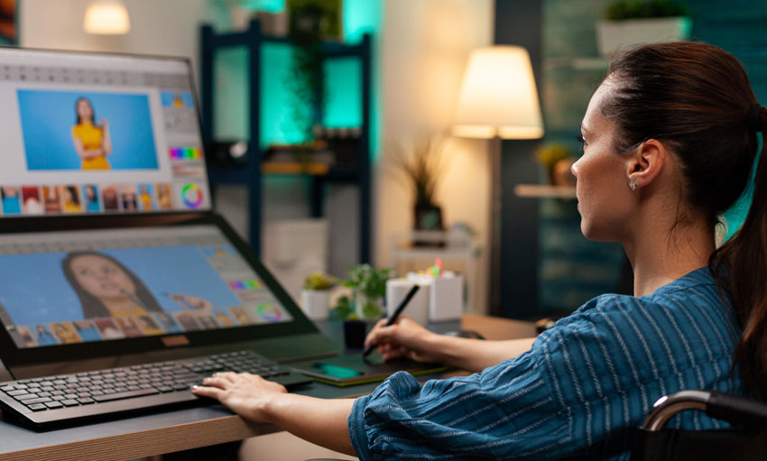 Young beautiful in glasses drawing on IPad tablet with latest pencil on photoshop